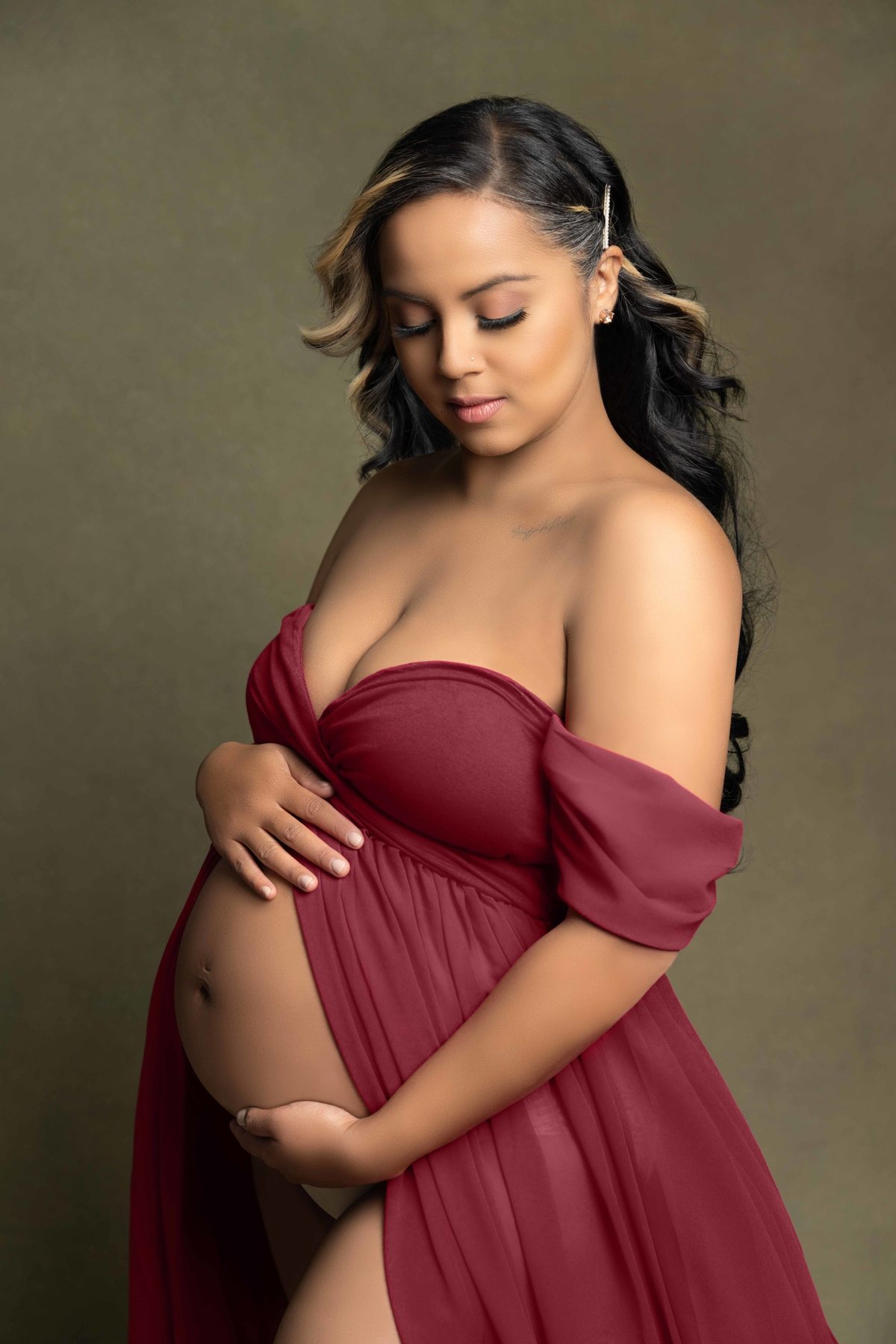 Expectant mother in a burgundy gown at a maternity photo session in Ontario